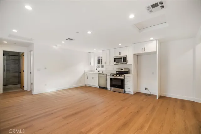 a view of kitchen with stainless steel appliances refrigerator stove microwave and cabinets