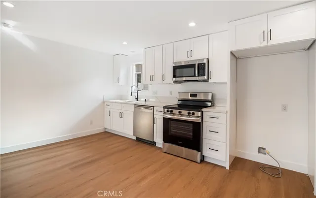 a kitchen with stainless steel appliances a stove top oven a sink and a refrigerator