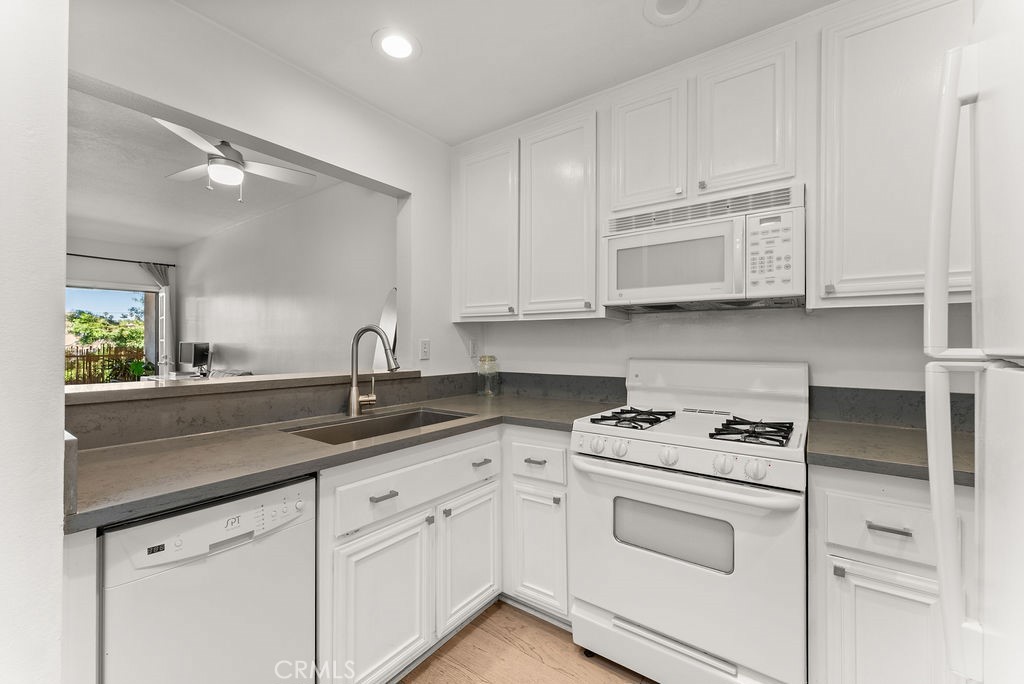 1145 Roswell Avenue, Unit 8A Long Beach, CA 90804 - Photo 11 of 35 a kitchen with white cabinets and white appliances