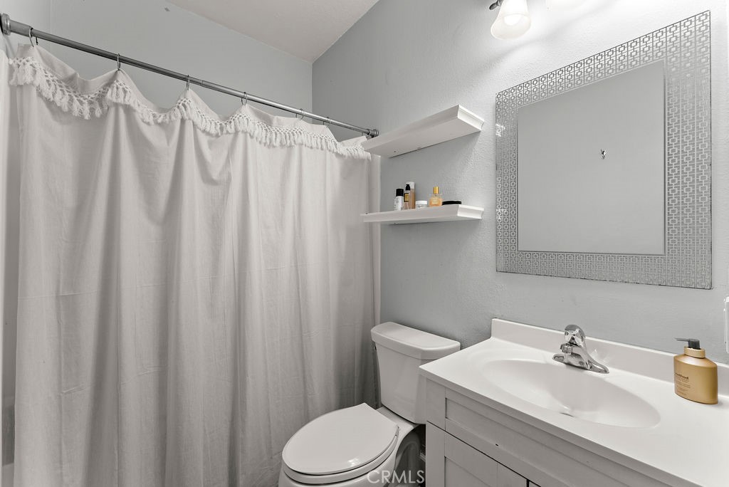 1145 Roswell Avenue, Unit 8A Long Beach, CA 90804 - Photo 14 of 35 a bathroom with a sink a toilet and shower curtain