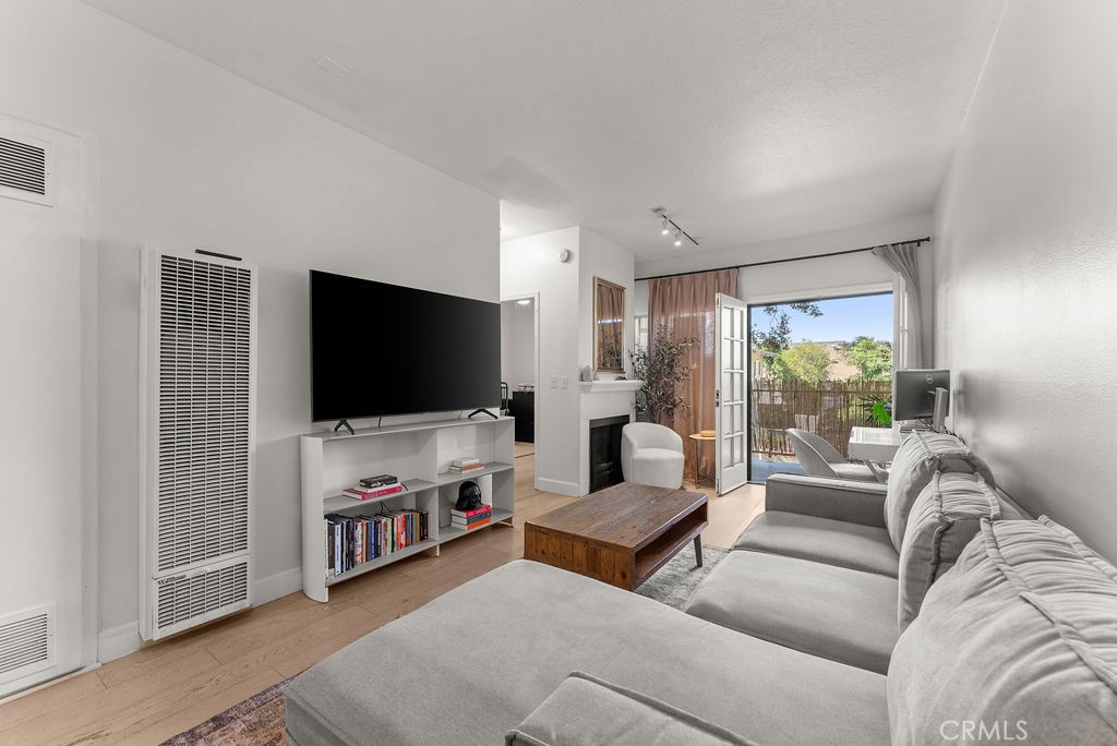 1145 Roswell Avenue, Unit 8A Long Beach, CA 90804 - Photo 2 of 35 a living room with furniture and a flat screen tv