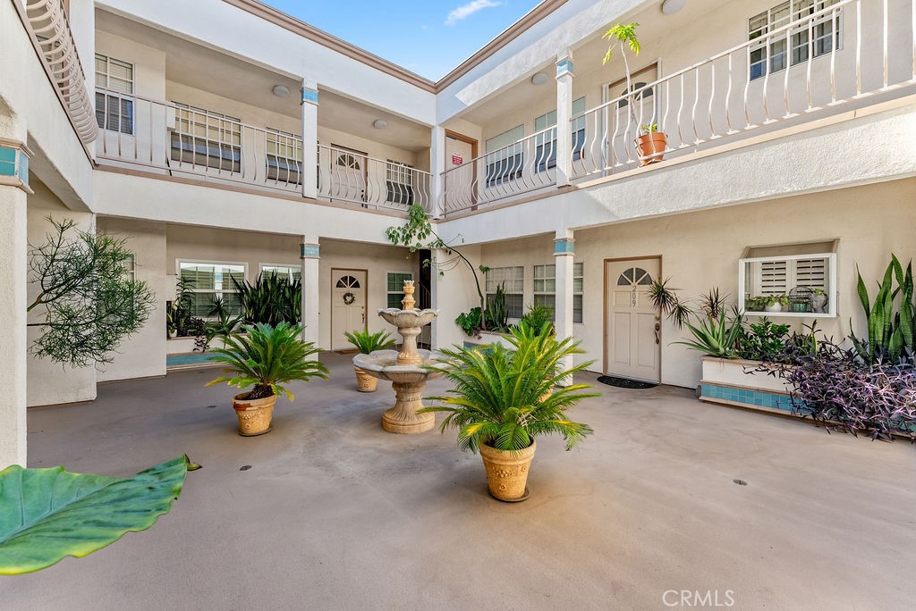 1145 Roswell Avenue, Unit 8A Long Beach, CA 90804 - Photo 23 of 35 front view of a building with potted plants and a bench