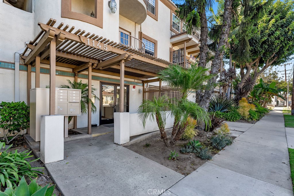 1145 Roswell Avenue, Unit 8A Long Beach, CA 90804 - Photo 29 of 35 a view of a patio with a table and chairs under an umbrella with potted plants