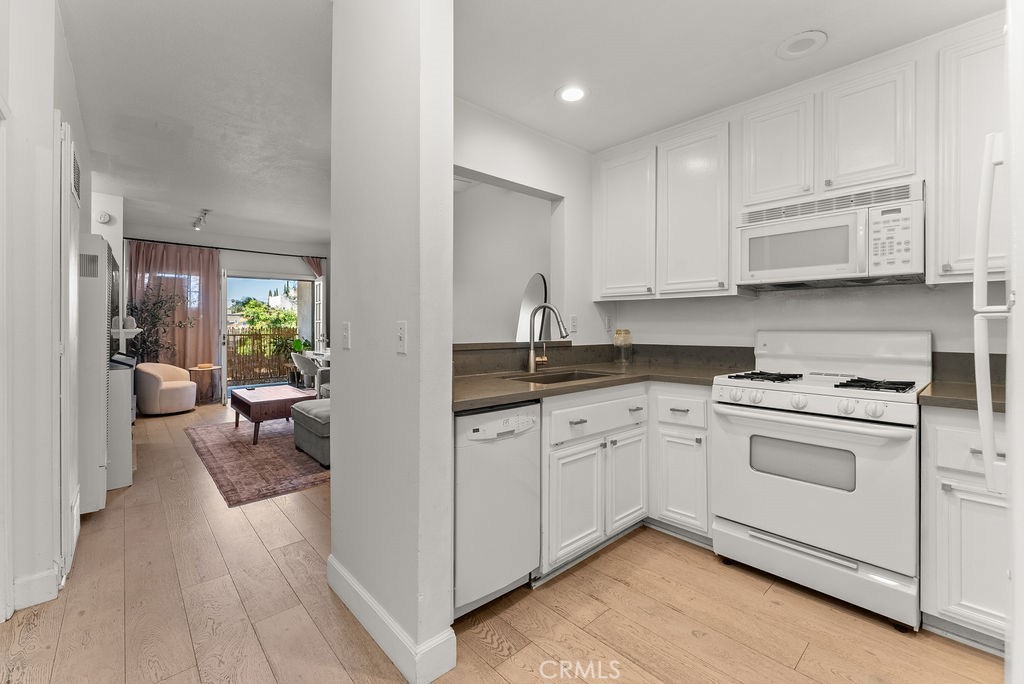 1145 Roswell Avenue, Unit 8A Long Beach, CA 90804 - Photo 7 of 35 a kitchen with white cabinets and appliances