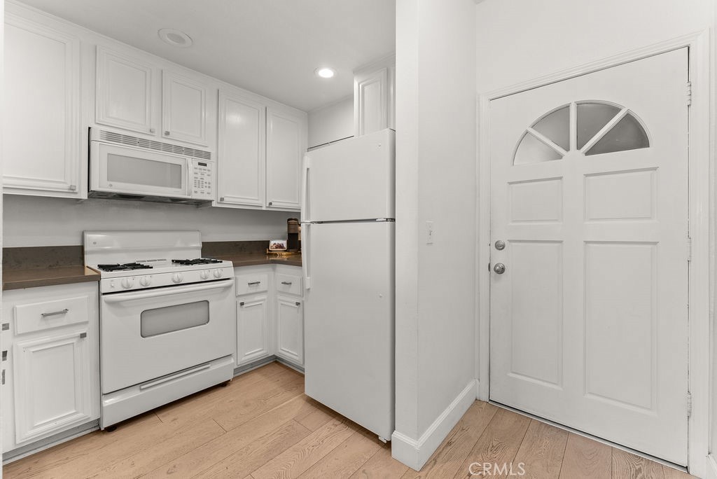 1145 Roswell Avenue, Unit 8A Long Beach, CA 90804 - Photo 8 of 35 a kitchen with white cabinets and white appliances