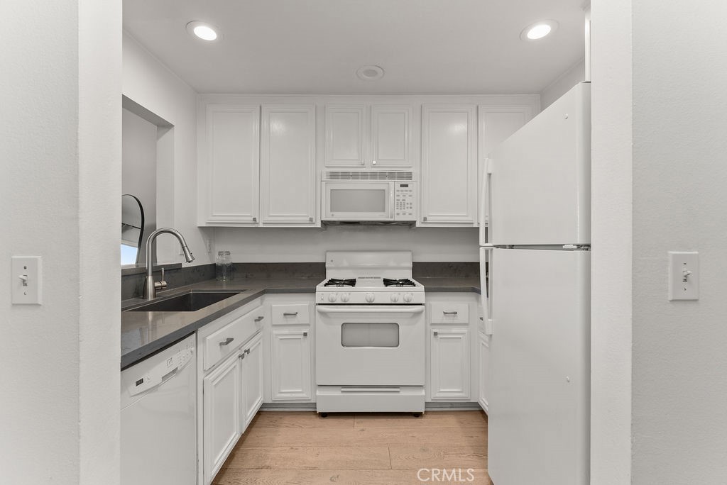 1145 Roswell Avenue, Unit 8A Long Beach, CA 90804 - Photo 9 of 35 a kitchen with white cabinets and white appliances