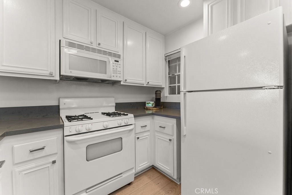 1145 Roswell Avenue, Unit 8A Long Beach, CA 90804 - Photo 10 of 35 a kitchen with white cabinets and white appliances