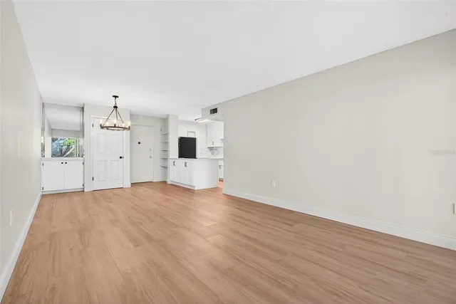 a view of empty room with wooden floor and windows