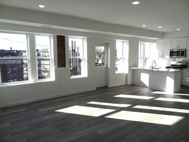 a view of a kitchen with wooden floor and a kitchen