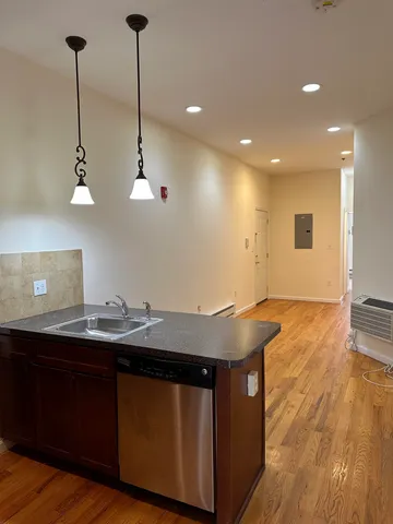 a kitchen with a sink a counter space and wooden floor