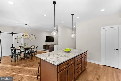 a view of a dining room and livingroom with furniture wooden floor a chandelier