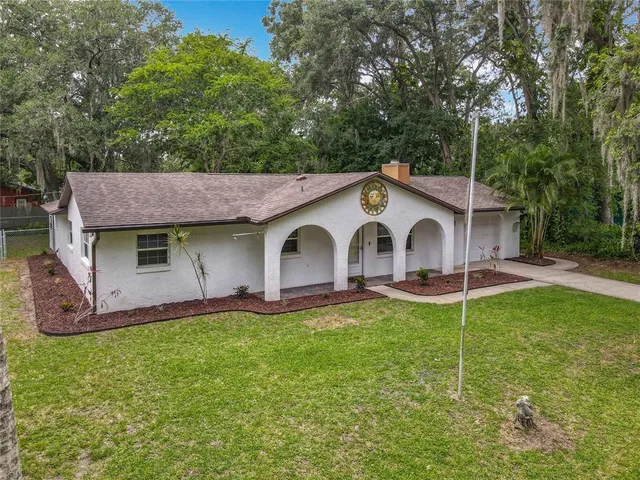 a view of a house with a yard and sitting area