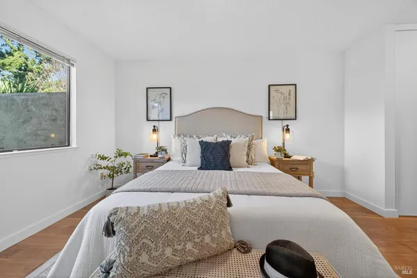 a bedroom with a bed and painting on the wall