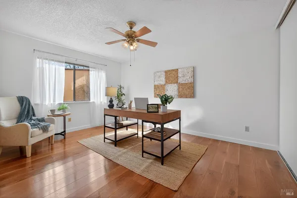 a view of a livingroom with furniture and a dining table with projector screen