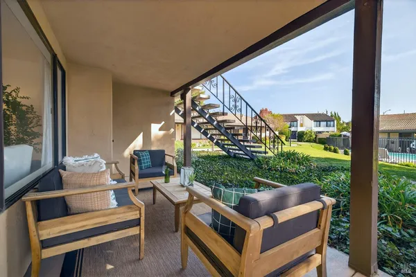 a view of a chair and tables in the balcony