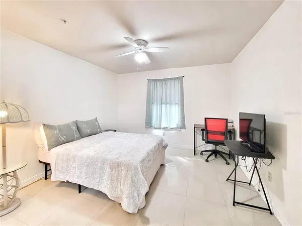 a bedroom with a bed projector and a chair
