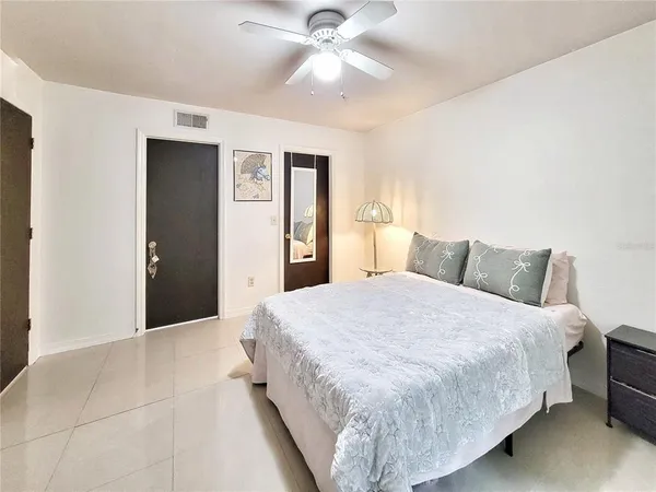 a bedroom with a bed and a ceiling fan