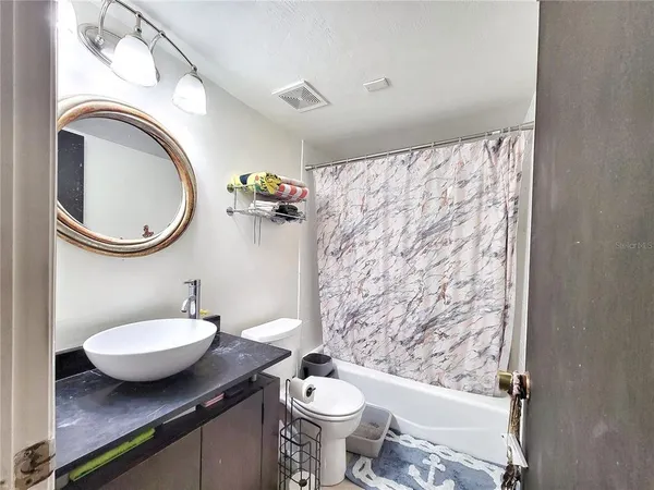 a bathroom with a granite countertop toilet a sink and a mirror