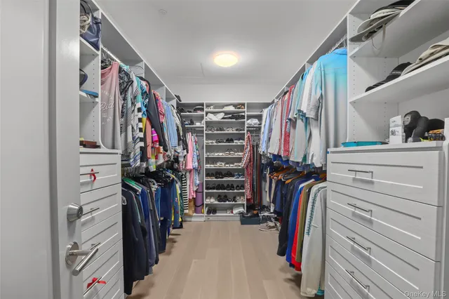a view of walk in closet with clothes