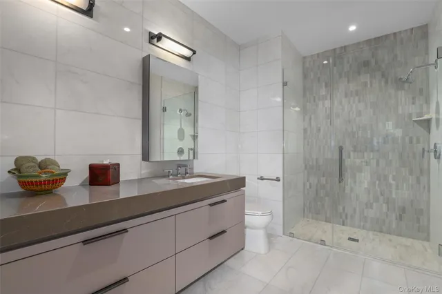 a bathroom with a granite countertop sink a toilet and shower