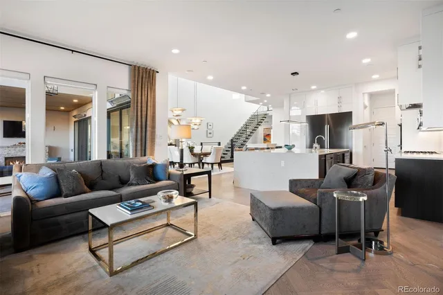 a living room with furniture kitchen view and a wooden floor