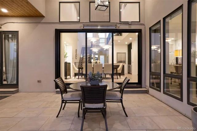 a dining room with furniture and a floor to ceiling window