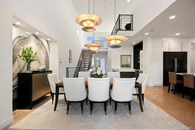 a view of a dining room with furniture a chandelier and wooden floor