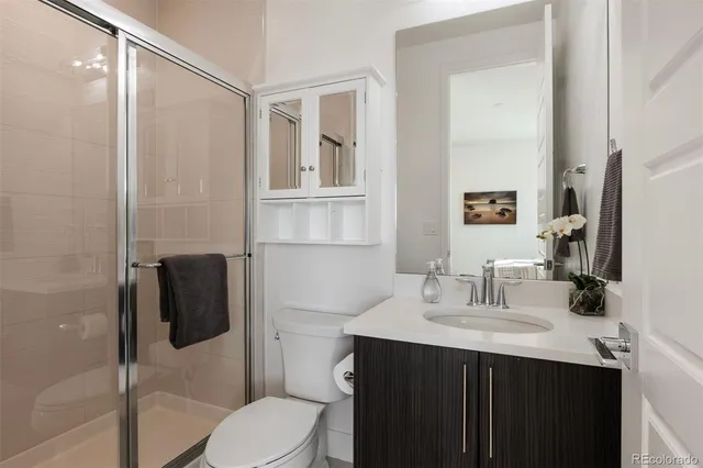 a bathroom with a sink vanity toilet and shower