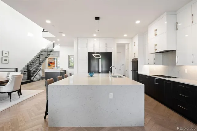 a large kitchen with stainless steel appliances kitchen island granite countertop a sink and a refrigerator