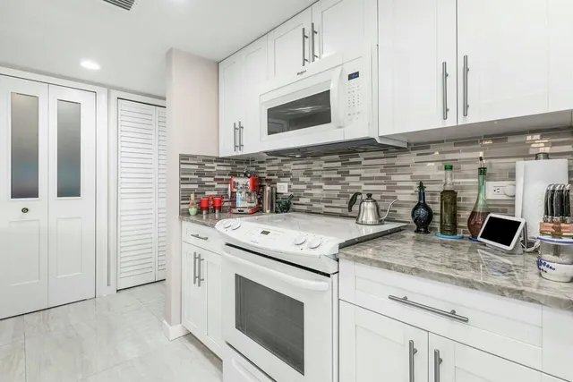 a kitchen with stainless steel appliances granite countertop a sink and a microwave