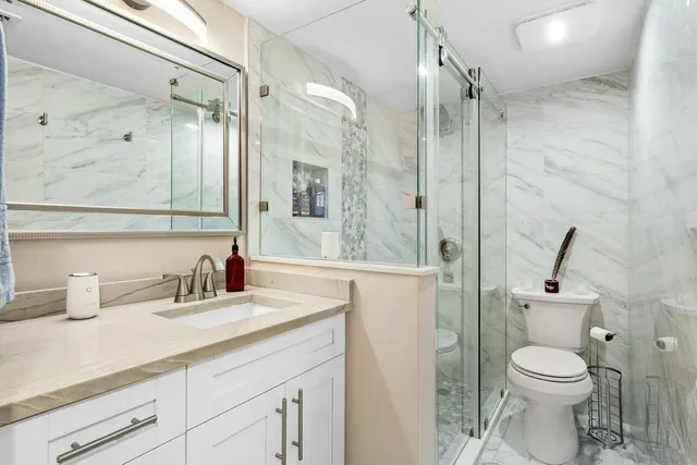 a bathroom with a sink a toilet and shower