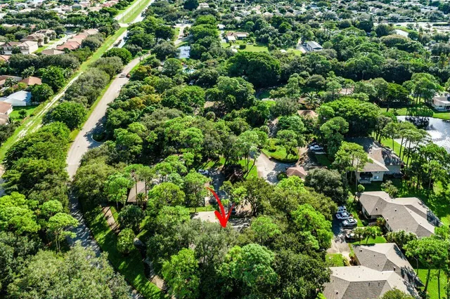 an aerial view of residential houses with outdoor space and trees