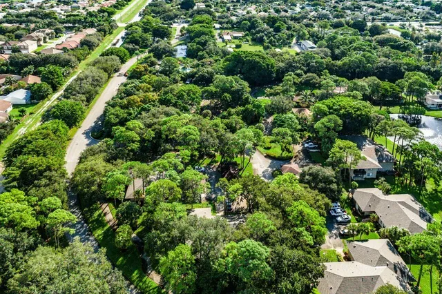 an aerial view of residential house with outdoor space and trees all around