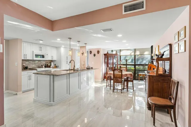 a kitchen with white cabinets and chairs