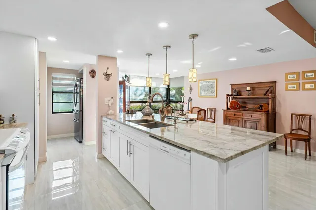 a kitchen with stainless steel appliances granite countertop a refrigerator a sink and a stove