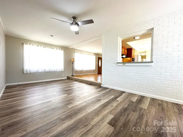 a view of a livingroom with wooden floor and a ceiling fan