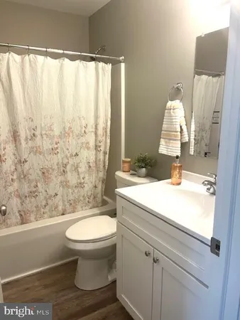 a bathroom with a granite countertop sink a toilet and a shower