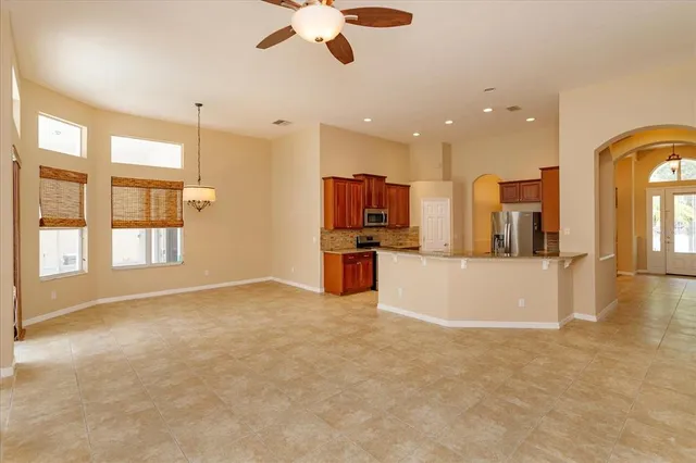 a view of a kitchen with kitchen island stainless steel appliances windows a sink and a counter top space