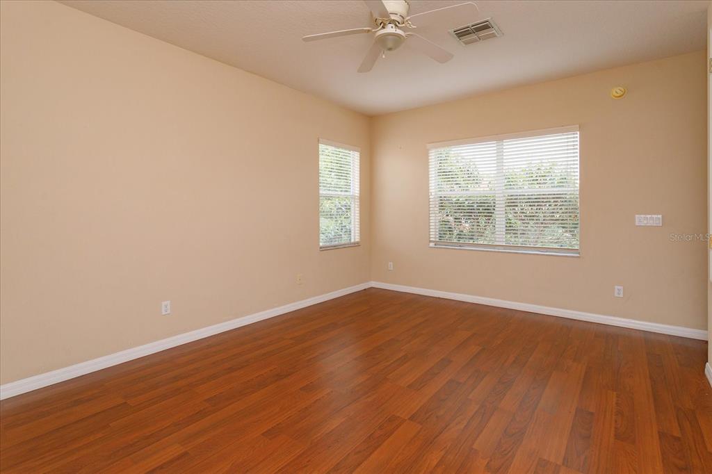 11445 Vicolo Loop Windermere, FL 34786 - Photo 18 of 28 an empty room with wooden floor windows and fan