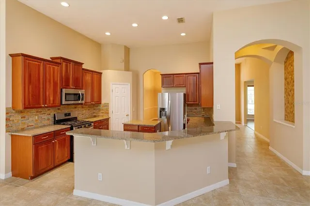a kitchen with stainless steel appliances granite countertop a stove a sink and a refrigerator