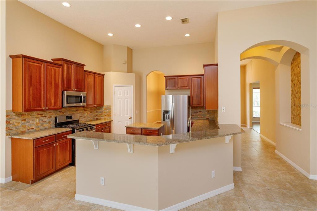 11445 Vicolo Loop Windermere, FL 34786 - Photo 7 of 28 a kitchen with stainless steel appliances granite countertop a stove a sink and a refrigerator