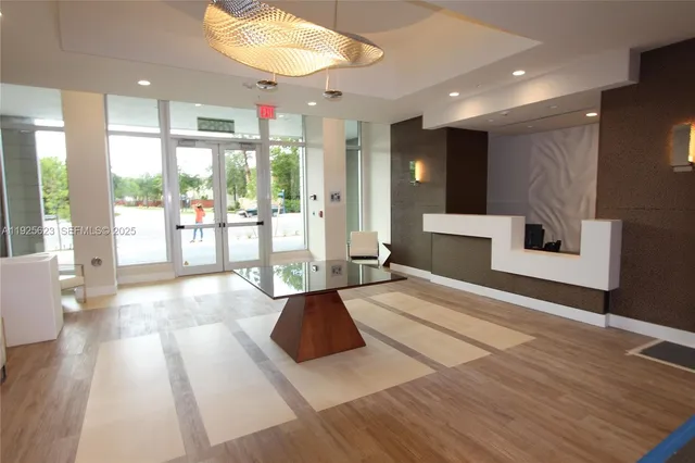 a front view of multi story residential apartment building with yard and sign board