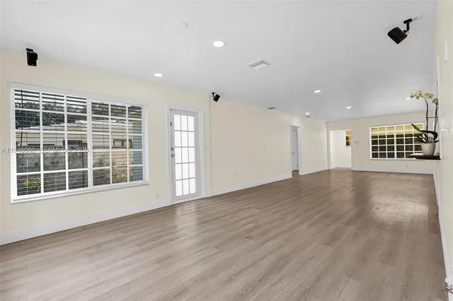 a view of an empty room with wooden floor