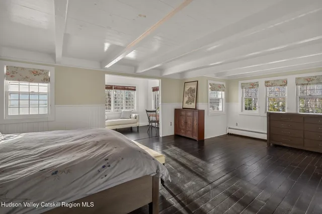 a spacious bedroom with a balcony a bed and wooden floor