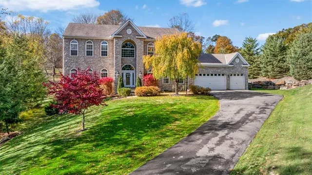 a front view of a house with a yard and fountain