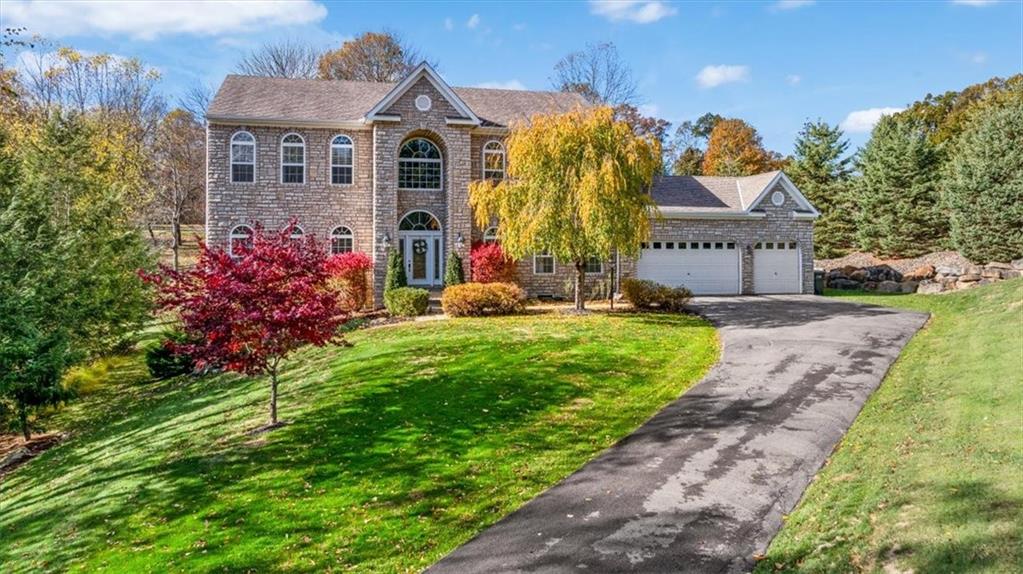 a front view of a house with a yard and fountain