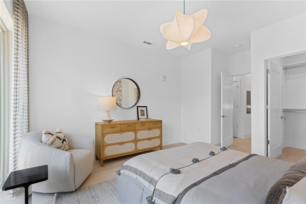 775 Juniper Street Northeast, Unit 227 Atlanta, GA 30308 - Photo 14 of 42 a bedroom with bed and a chandelier