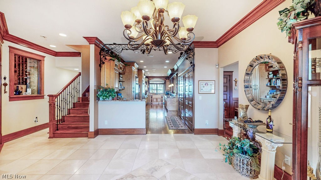 1431 Cedar Point Road Sandusky, OH 44870 - Photo 6 of 50 Entryway with ornamental molding, a chandelier, stairs, and recessed lighting