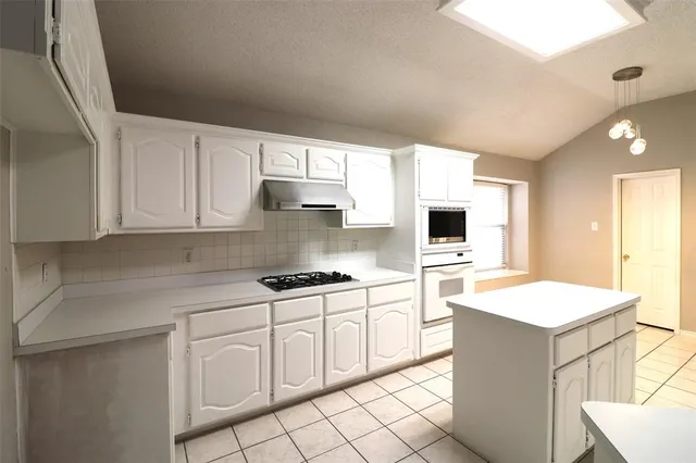 a kitchen with white cabinets and white appliances