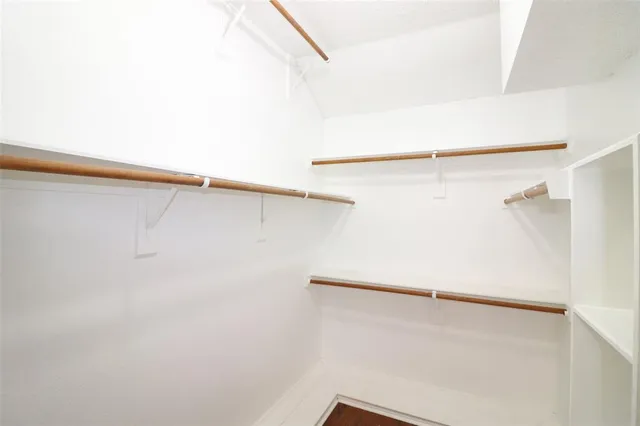a view of walk in closet with empty racks